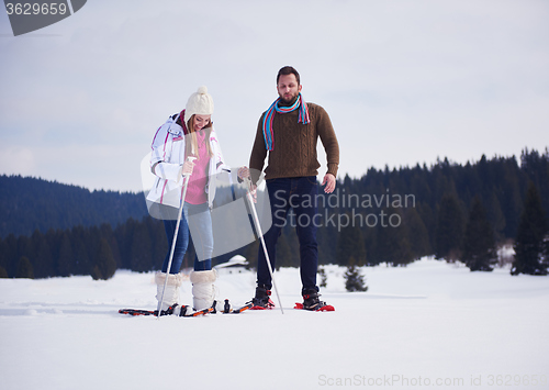 Image of couple having fun and walking in snow shoes