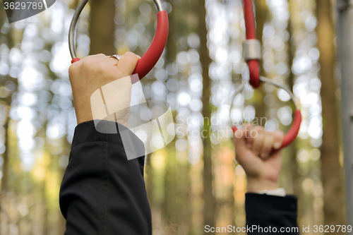 Image of hands on outdoor fitness machine