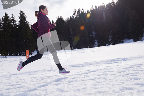 Image of yougn woman jogging outdoor on snow in forest