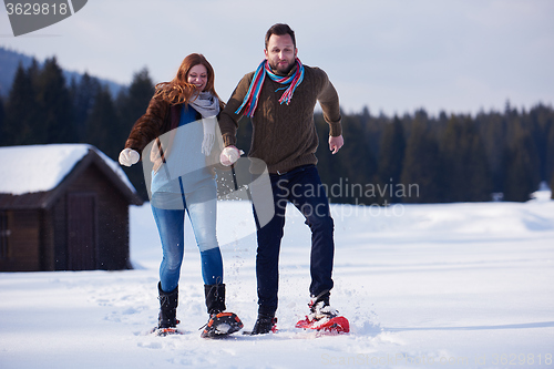 Image of couple having fun and walking in snow shoes