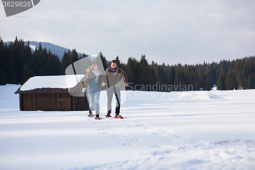 Image of couple having fun and walking in snow shoes