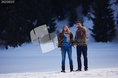 Image of couple having fun and walking in snow shoes