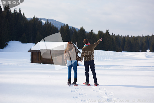 Image of couple having fun and walking in snow shoes