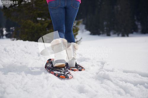 Image of couple having fun and walking in snow shoes