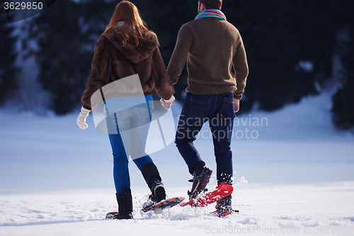 Image of couple having fun and walking in snow shoes