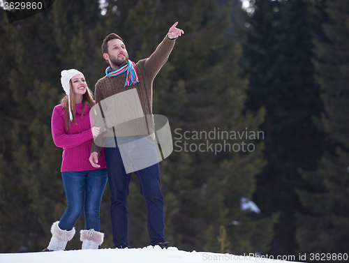 Image of couple having fun and walking in snow shoes