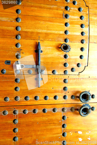 Image of brown  morocco in   old wood    home and rusty   padlock 