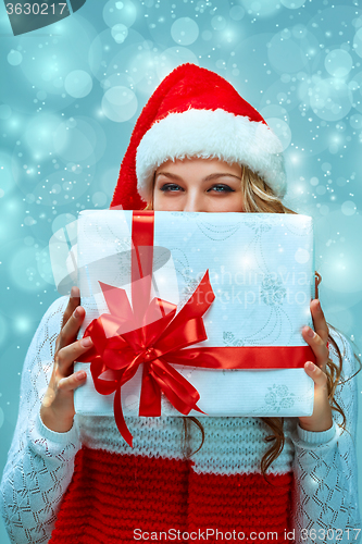 Image of Girl dressed in santa hat with a Christmas gift 