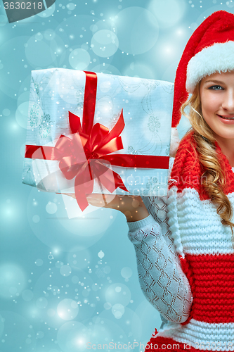 Image of Girl dressed in santa hat with a Christmas gift 