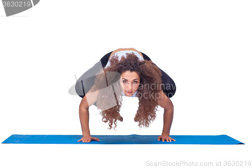 Image of Studio shot of a young fit woman doing yoga exercises.