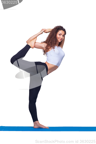 Image of Studio shot of a young fit woman doing yoga exercises.