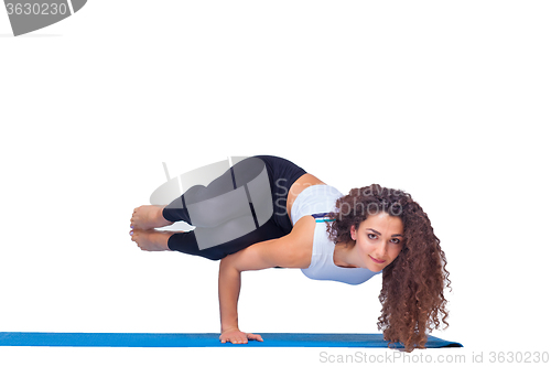 Image of Studio shot of a young fit woman doing yoga exercises.