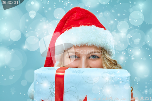 Image of Girl dressed in santa hat with a Christmas gift 