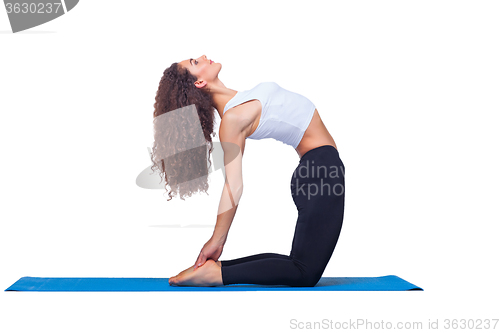 Image of Studio shot of a young fit woman doing yoga exercises.