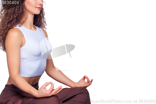 Image of Studio shot of a young fit woman doing yoga exercises.