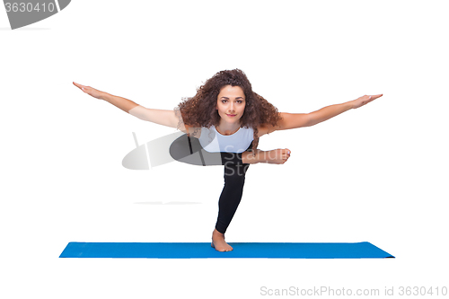 Image of Studio shot of a young fit woman doing yoga exercises.