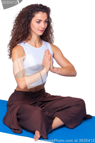 Image of Studio shot of a young fit woman doing yoga exercises.