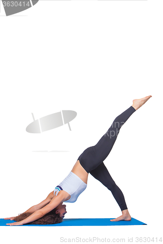 Image of Studio shot of a young fit woman doing yoga exercises.