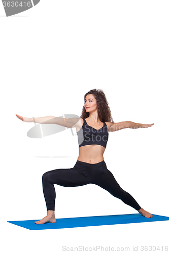 Image of Studio shot of a young fit woman doing yoga exercises.