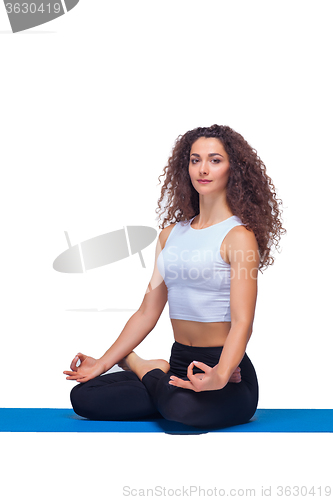 Image of Studio shot of a young fit woman doing yoga exercises.
