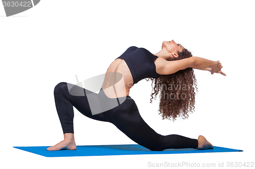 Image of Studio shot of a young fit woman doing yoga exercises.