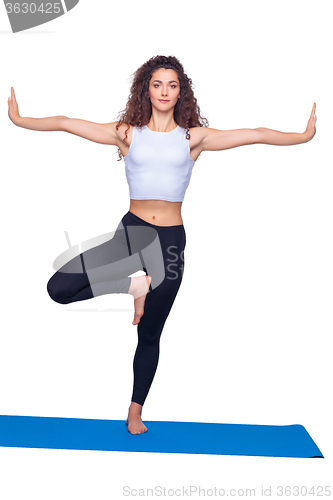 Image of Studio shot of a young fit woman doing yoga exercises.