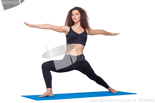 Image of Studio shot of a young fit woman doing yoga exercises.