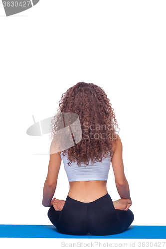 Image of Studio shot of a young fit woman doing yoga exercises.