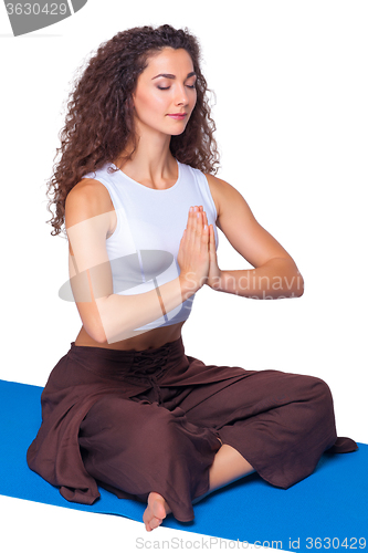 Image of Studio shot of a young fit woman doing yoga exercises.