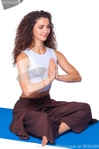 Image of Studio shot of a young fit woman doing yoga exercises.