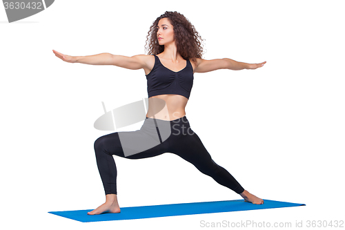 Image of Studio shot of a young fit woman doing yoga exercises.