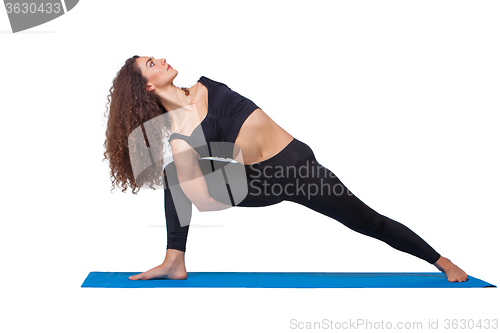 Image of Studio shot of a young fit woman doing yoga exercises.
