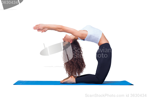 Image of Studio shot of a young fit woman doing yoga exercises.