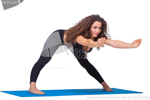 Image of Studio shot of a young fit woman doing yoga exercises.