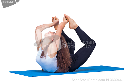 Image of Studio shot of a young fit woman doing yoga exercises.