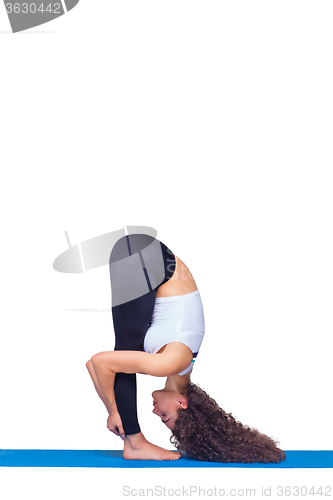 Image of Studio shot of a young fit woman doing yoga exercises.