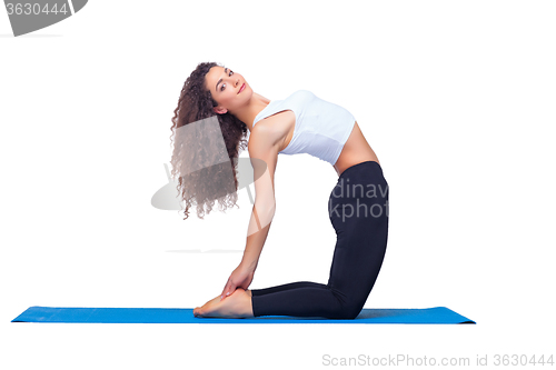 Image of Studio shot of a young fit woman doing yoga exercises.