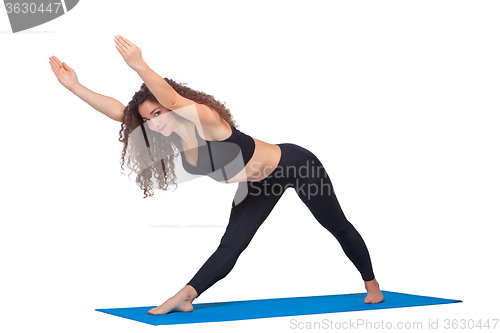 Image of Studio shot of a young fit woman doing yoga exercises.