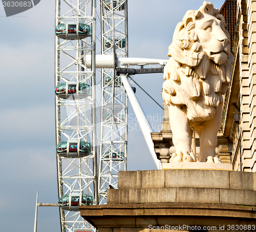 Image of lion  london eye in the spring sky and white clouds