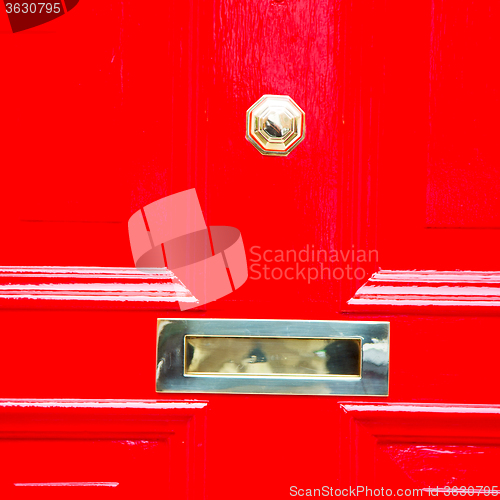 Image of red handle in london antique brown door  rusty  brass nail and l