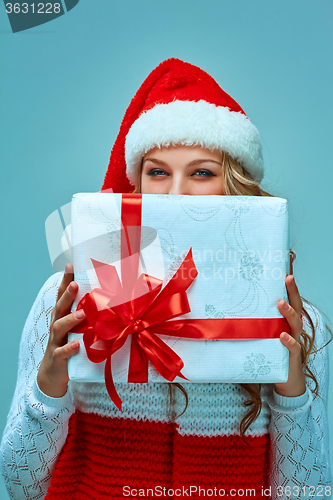 Image of Girl dressed in santa hat with a Christmas gift 