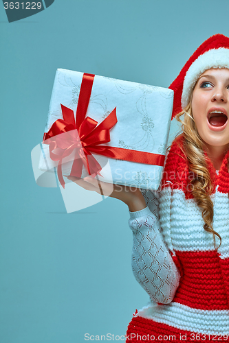 Image of Girl dressed in santa hat with a Christmas gift 