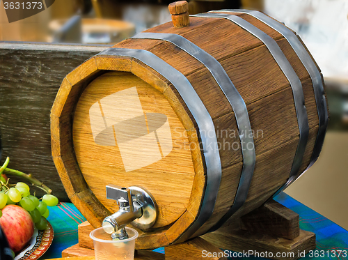 Image of Wooden oak wine barrel with metal tap.