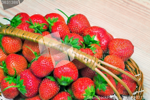 Image of Basket of strawberries on the table surface.