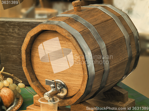 Image of Wooden oak wine barrel with metal tap.