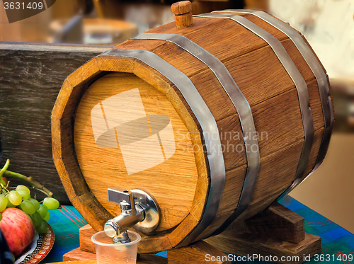 Image of Wooden oak wine barrel with metal tap.