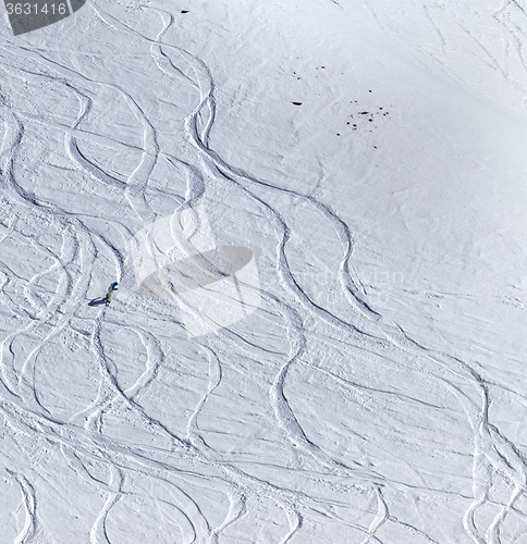 Image of Snowboarder downhill on off piste slope with newly-fallen snow