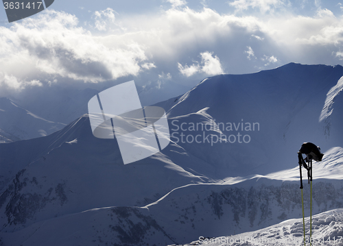 Image of Evening sunlight mountains and ski equipment