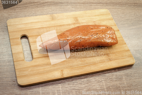 Image of smoked turkey meat on wooden chopping board 