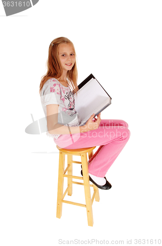 Image of Schoolgirl sitting with her schoolbook.